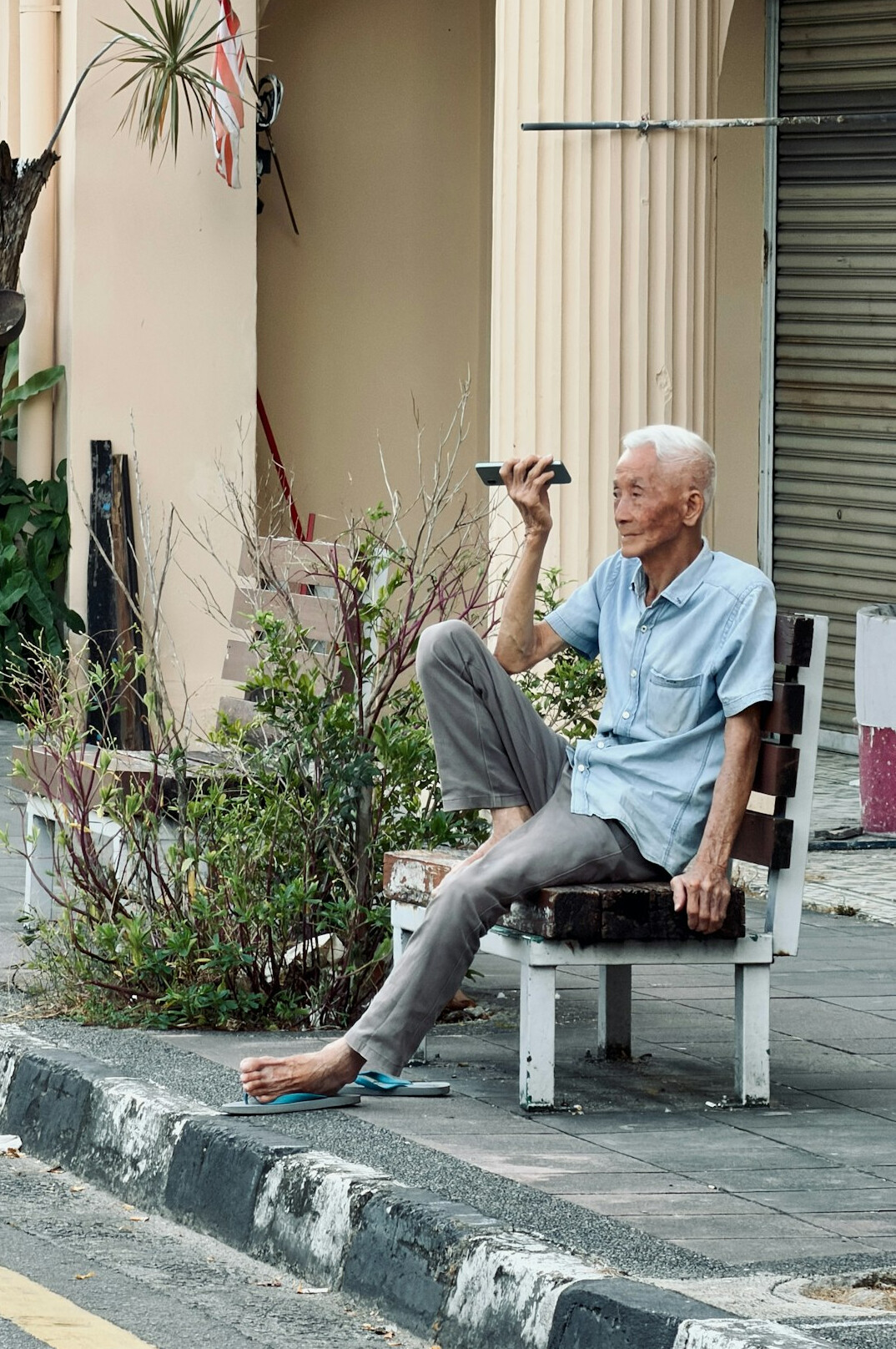 Elderly man resting on a street bench